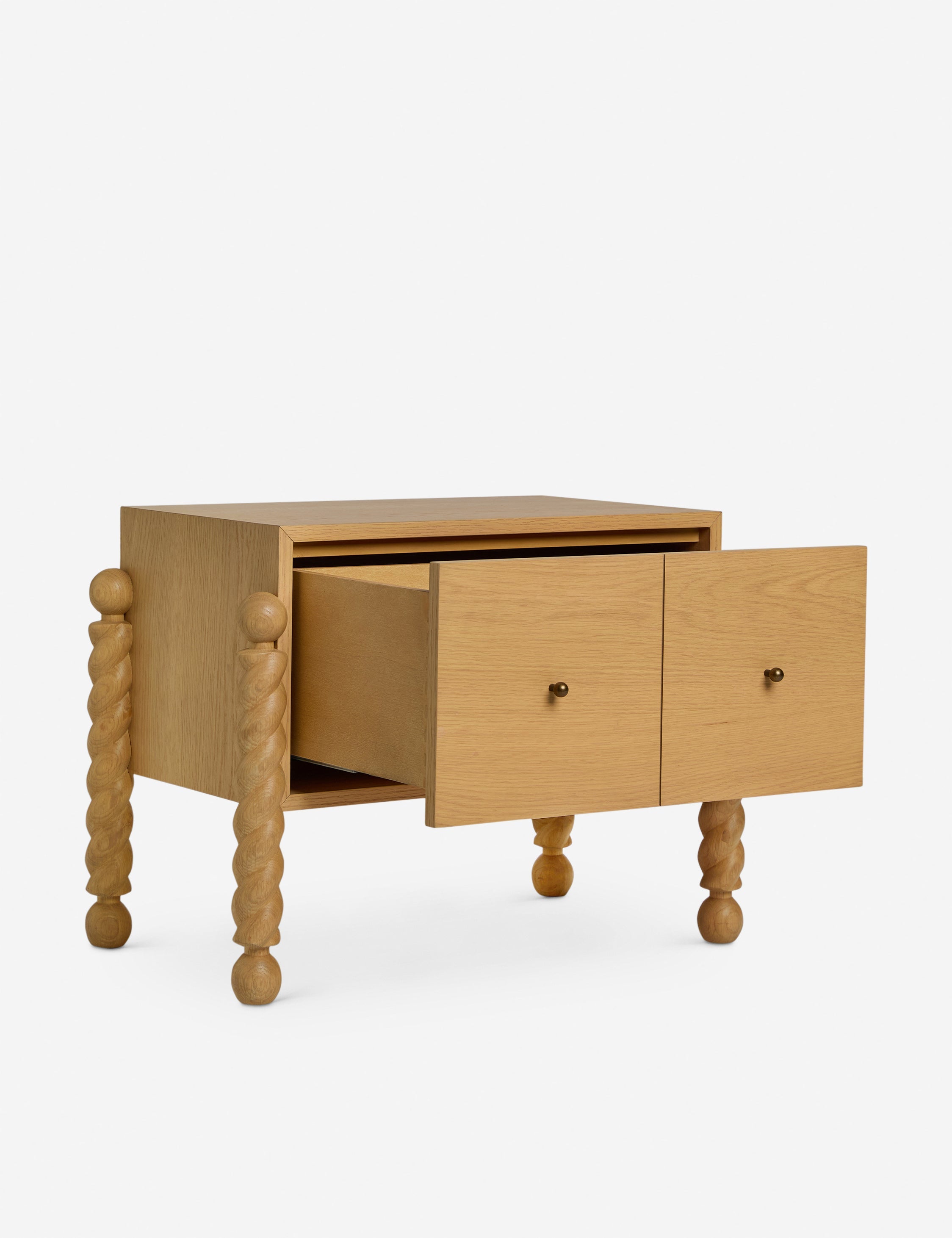 Table de chevet - Alliant avec raffinement formes et lignes, la table de chevet présente des pieds tournés sculpturaux qui encadrent une structure aux lignes épurées