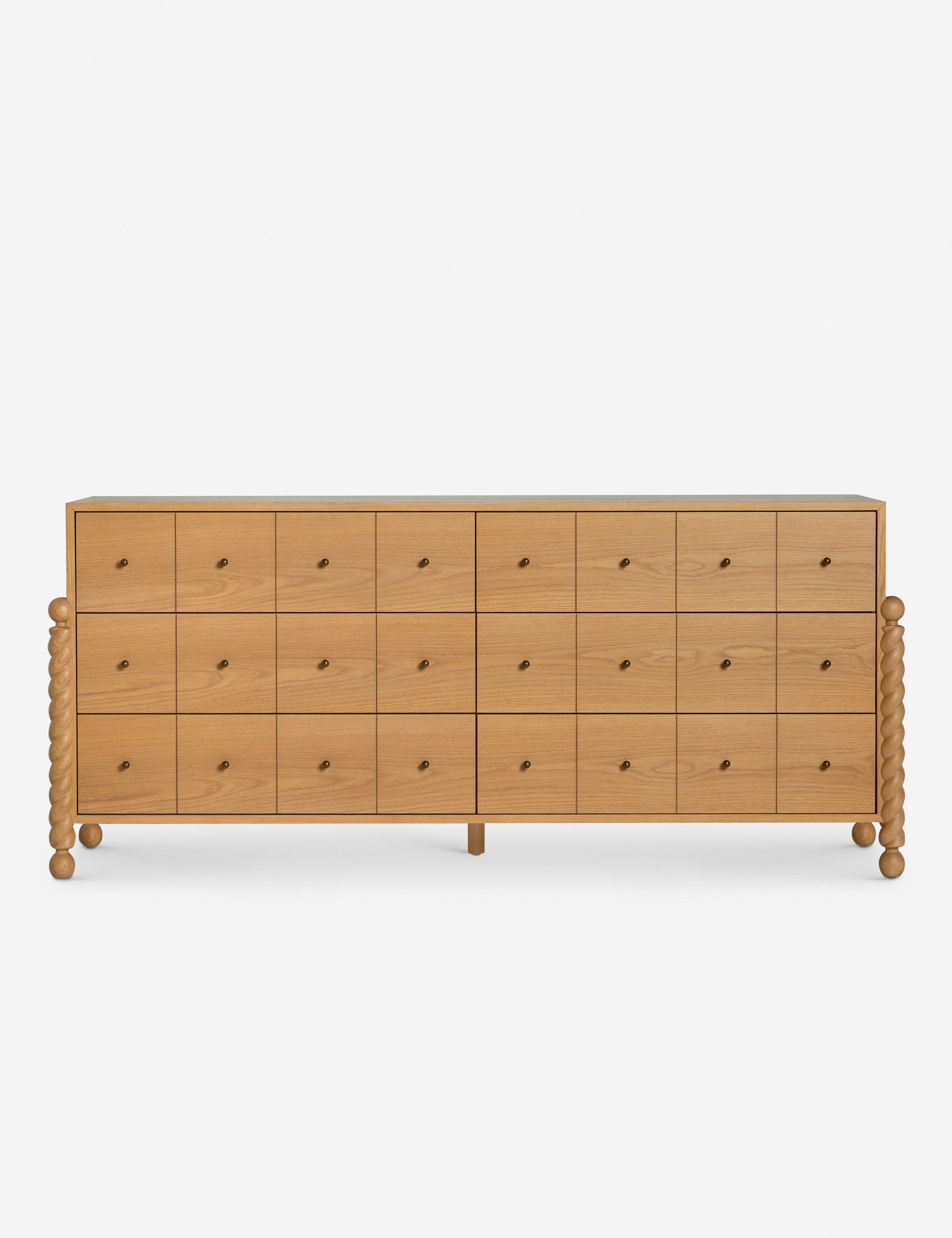 Commode à 6 tiroirs - Avec un mélange raffiné de formes et de lignes, cette commode présente des pieds tournés sculpturaux qui encadrent un caisson aux lignes épurées