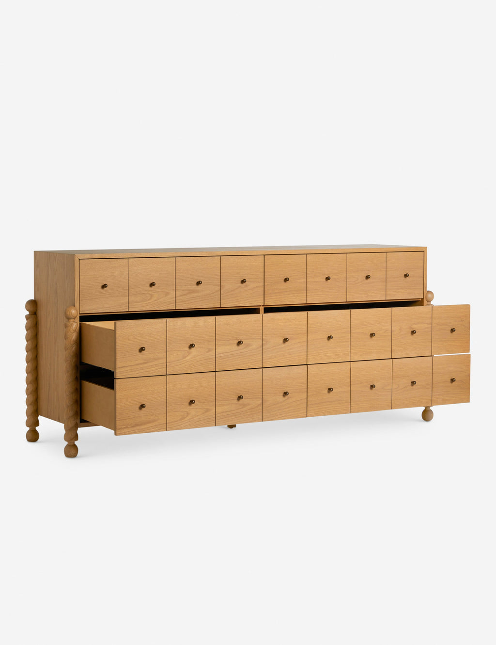 Commode à 6 tiroirs - Avec un mélange raffiné de formes et de lignes, cette commode présente des pieds tournés sculpturaux qui encadrent un caisson aux lignes épurées