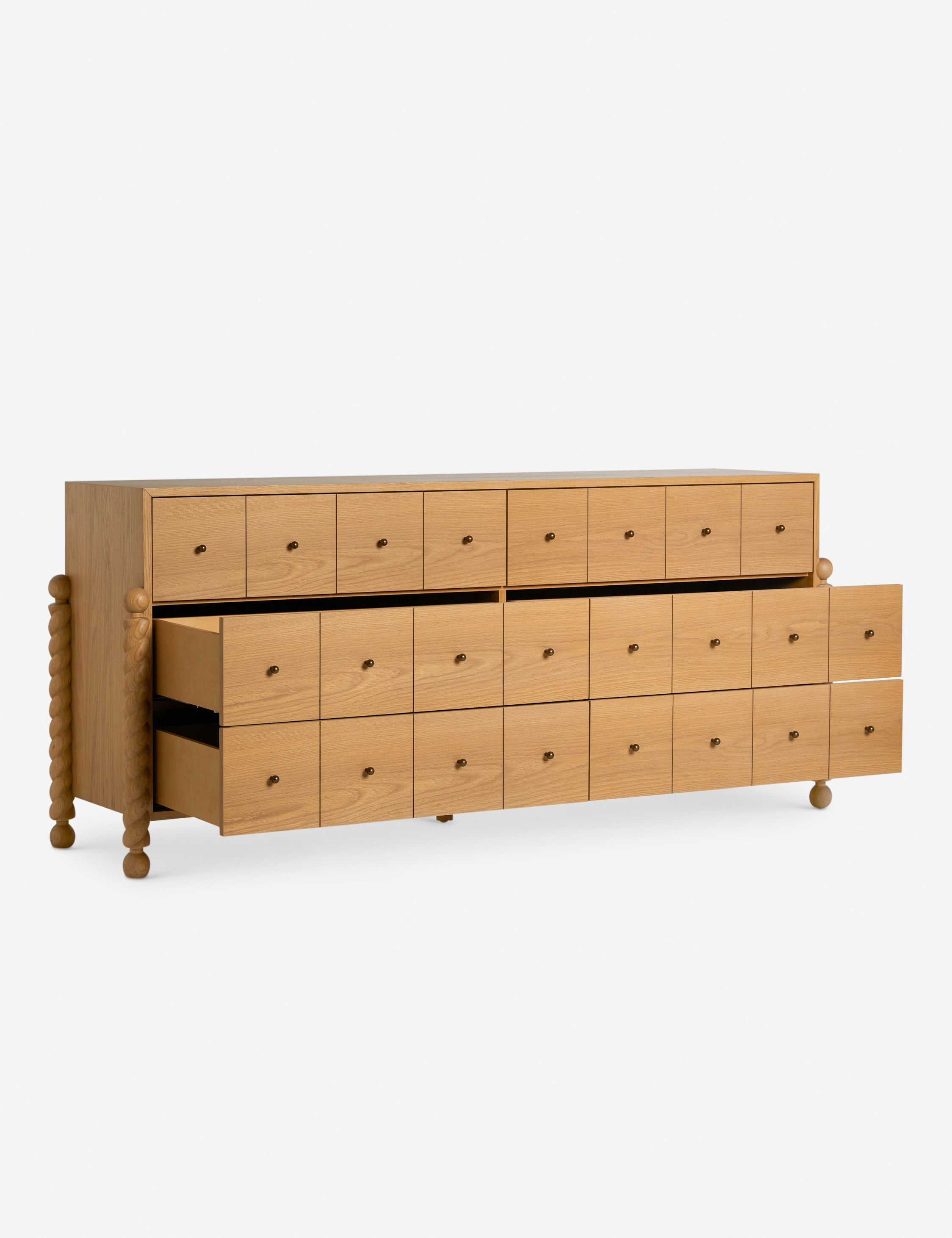 Commode à 6 tiroirs - Avec un mélange raffiné de formes et de lignes, cette commode présente des pieds tournés sculpturaux qui encadrent un caisson aux lignes épurées
