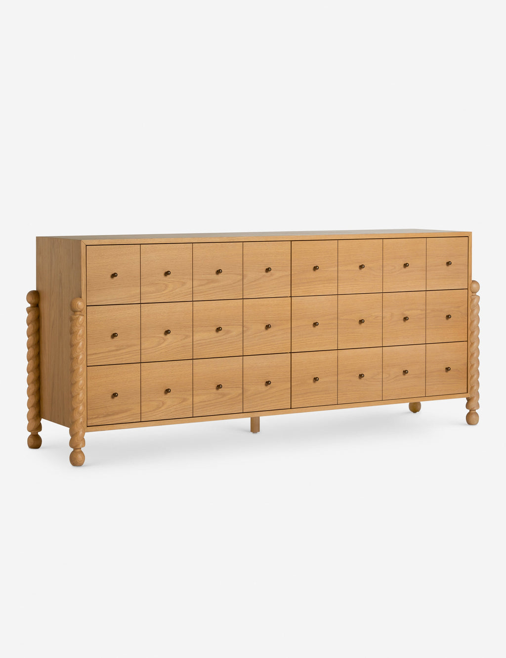 Commode à 6 tiroirs - Avec un mélange raffiné de formes et de lignes, cette commode présente des pieds tournés sculpturaux qui encadrent un caisson aux lignes épurées