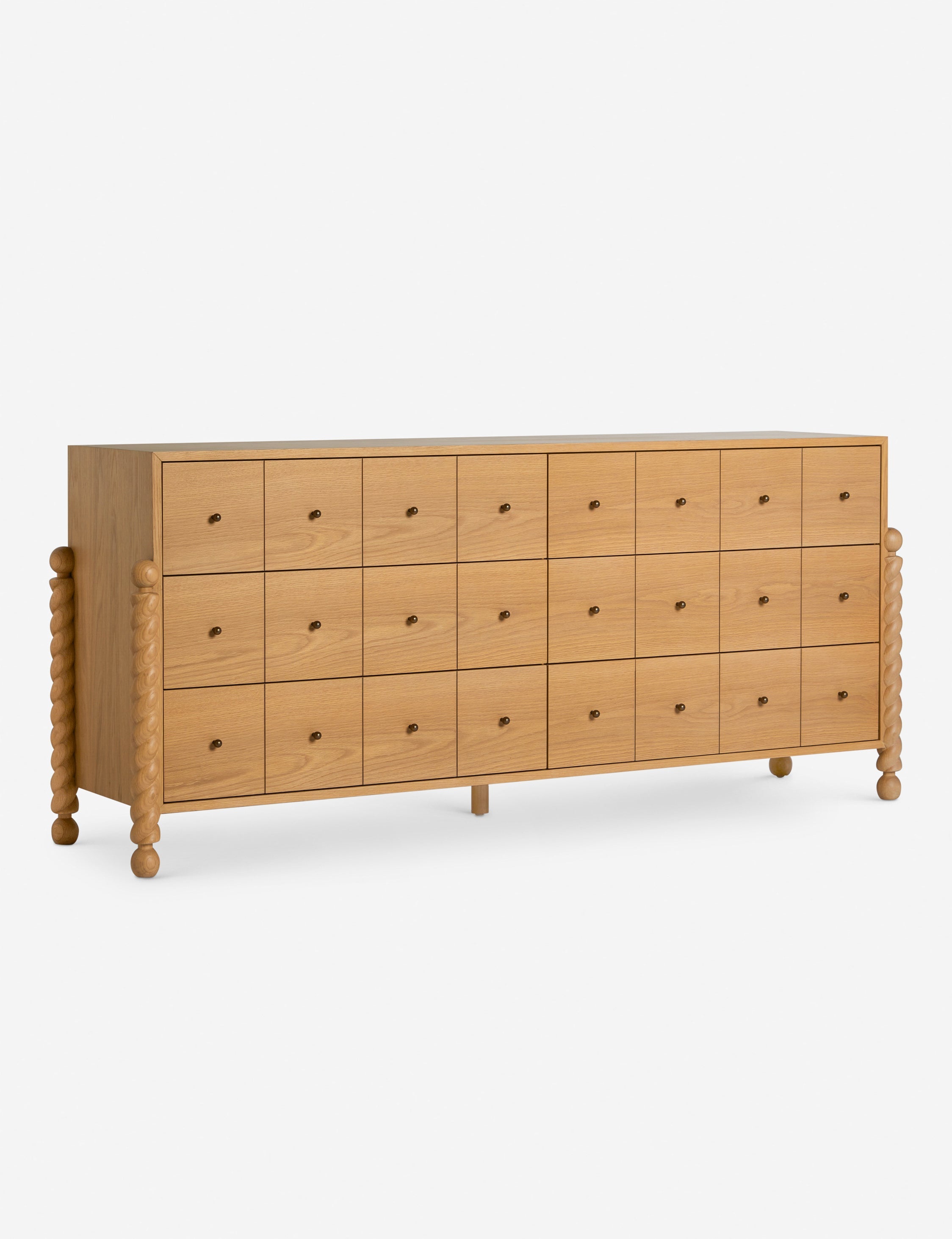 Commode à 6 tiroirs - Avec un mélange raffiné de formes et de lignes, cette commode présente des pieds tournés sculpturaux qui encadrent un caisson aux lignes épurées