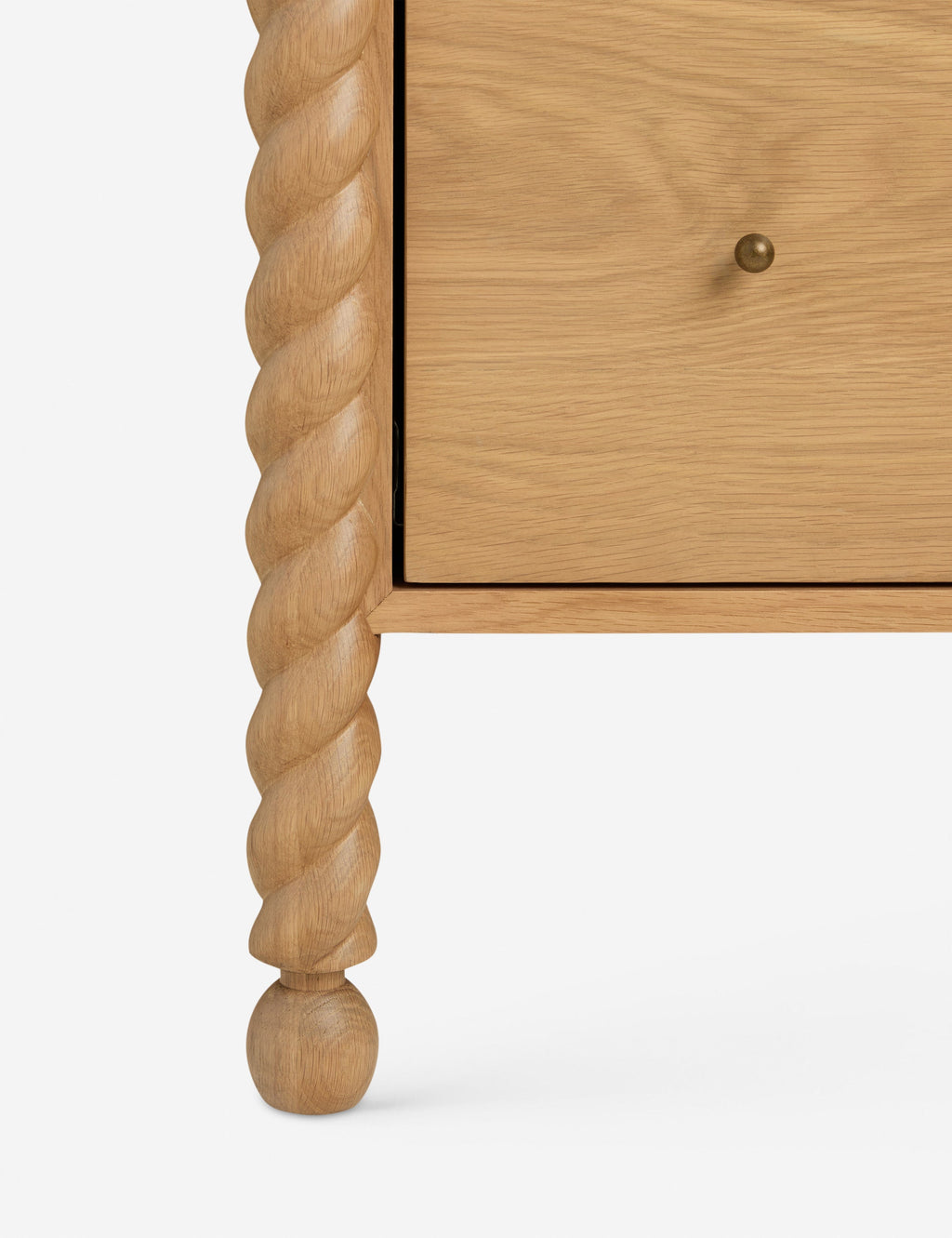 Commode haute - Mélange raffiné de formes et de lignes, cette commode présente des pieds sculptés tournés qui encadrent une structure aux lignes épurées